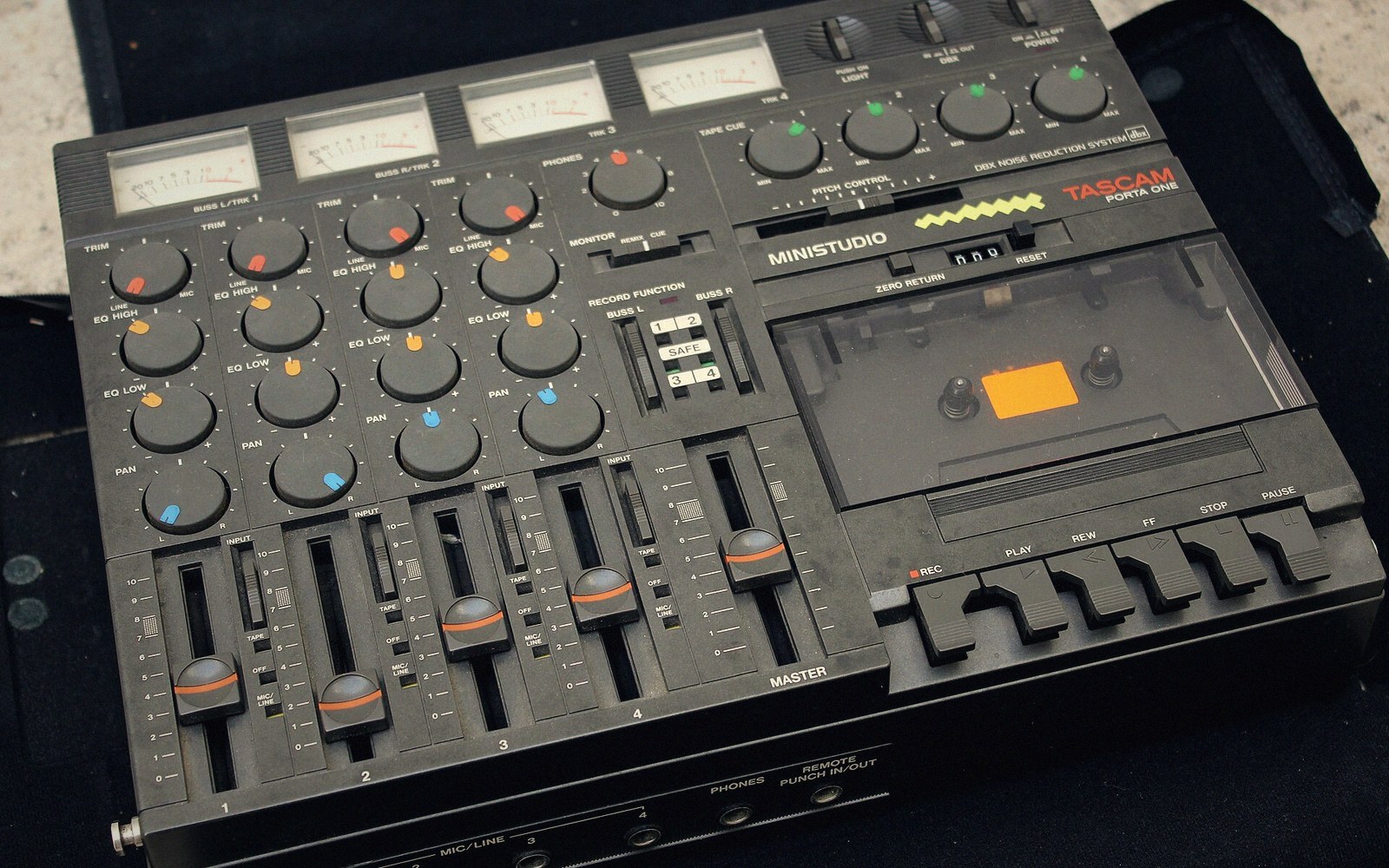 A Tascam Ministudio Porta One four-track cassette recorder with mixer knobs and sliding faders
