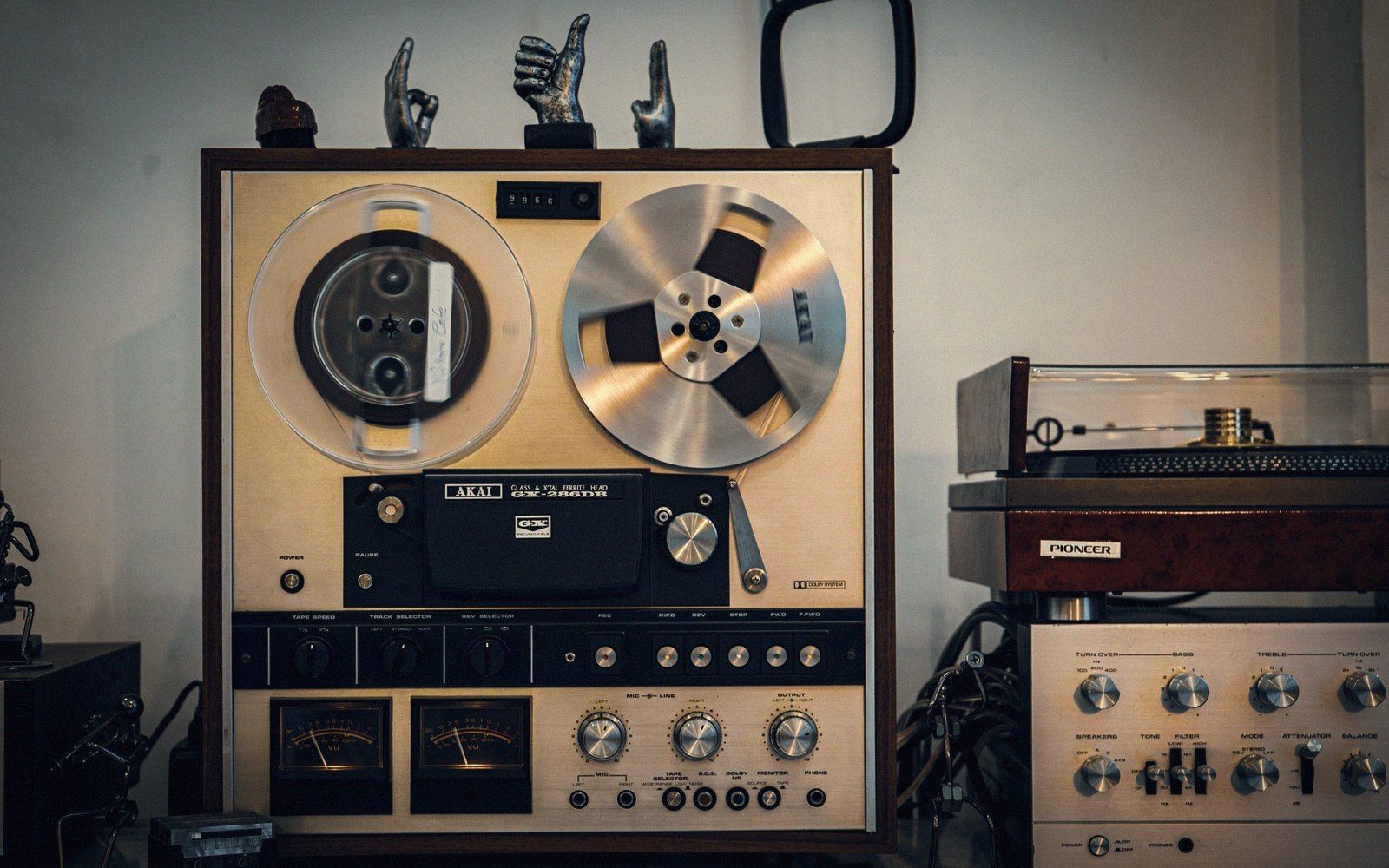 A vintage Akai reel-to-reel tape recorder beside a Pioneer turntable and amplifier